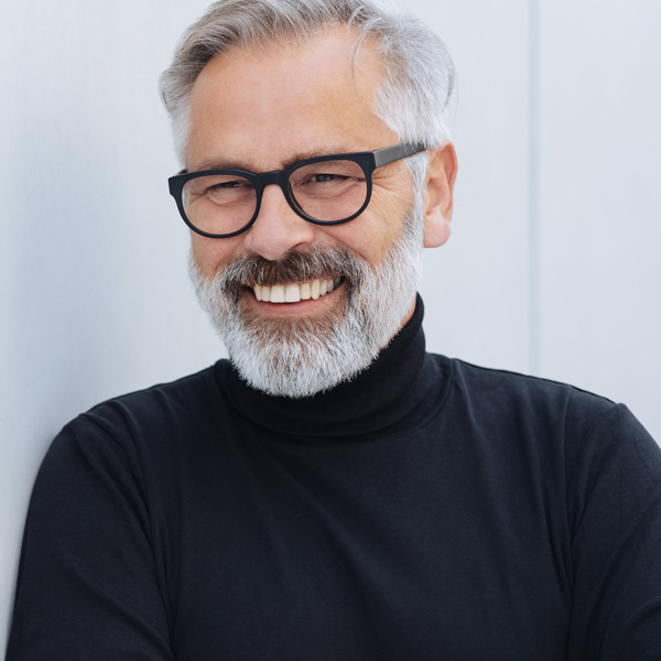 senior man with glasses and turtleneck smiling