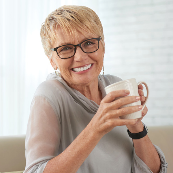 senior woman with coffee in hand, smiling