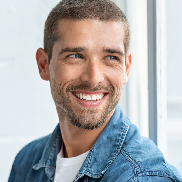 man in blue jean jacket smiling